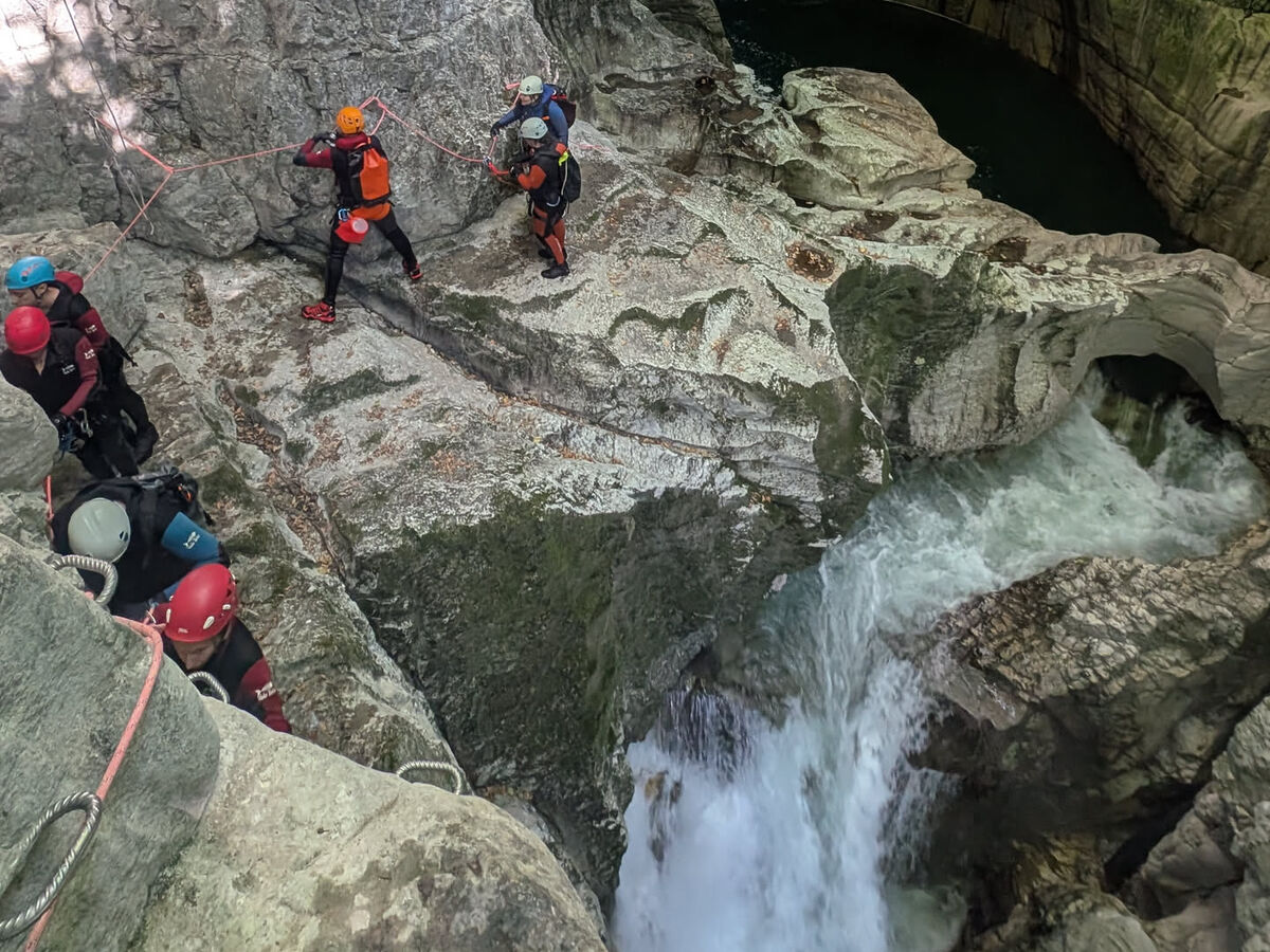 Groupe du club en main courante au-dessus d'une cascade