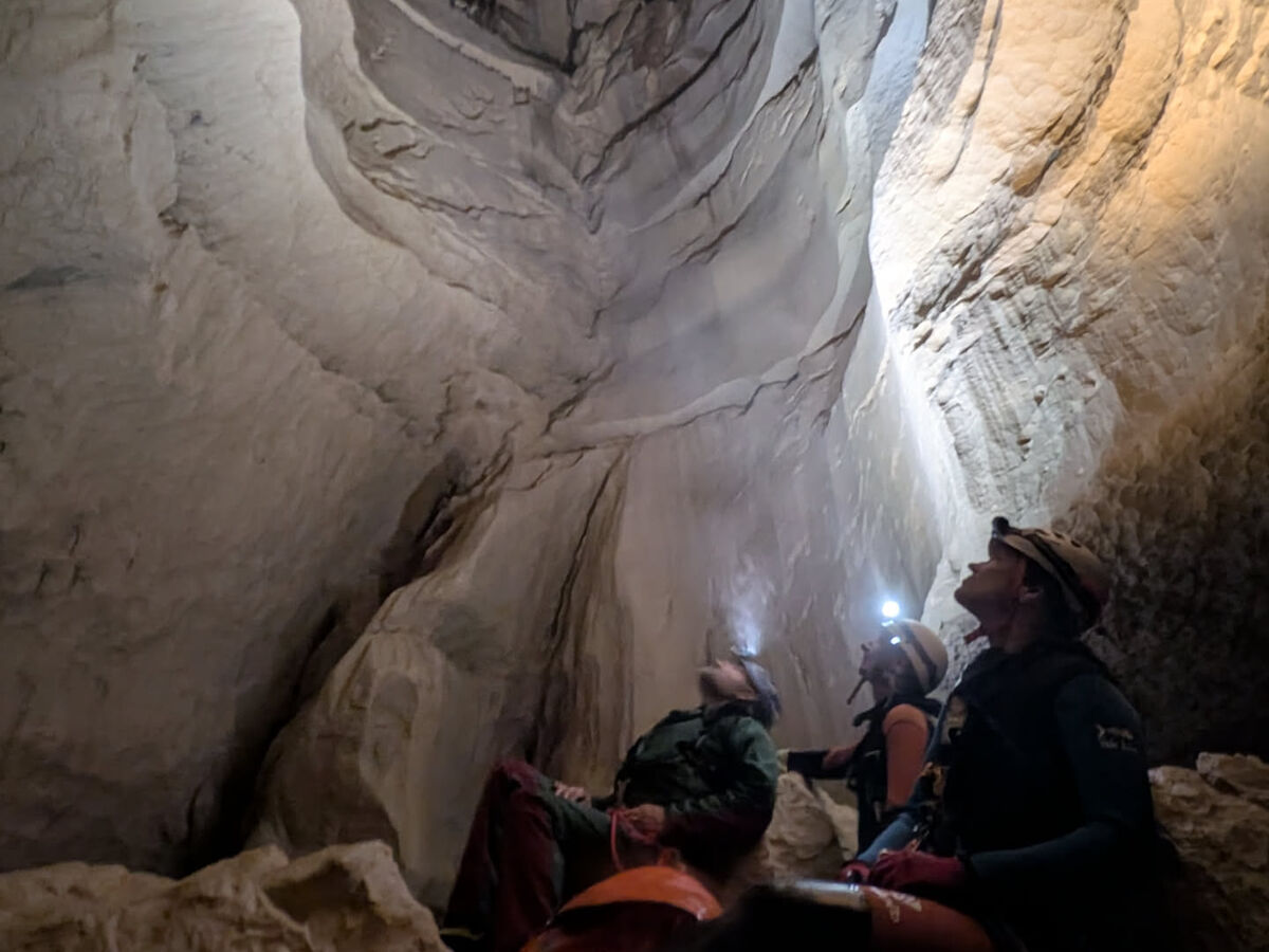 Spéléologues levant les yeux vers un grand puits dans la grotte de Gournier