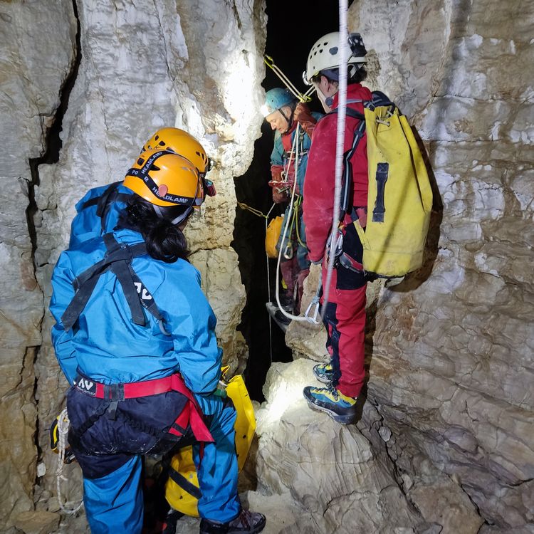 Spéléologues sur corde dans une galerie